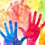 Coloured hands reaching up to the sky. Donate.